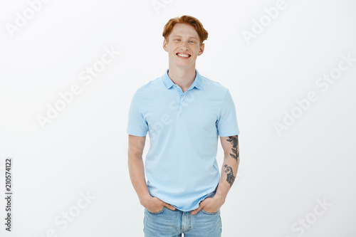 Joyful Handsome Male With Ginger Hair And Tattoed Arm Holding