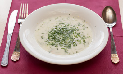 White cold soup with vegetables on a serving table