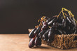 © ronnarong - Black seedless moon drops grape or Witch fingers grape in basket with black background. copy space