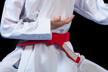 Aikido red belt on white kimono on black background