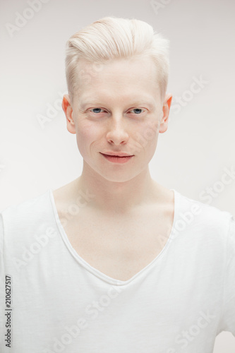 Fotografie, Obraz Albino man with hairstyle dressed in blank white t-shirt looking at camera isolated over white backgrond