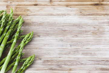 bunch of green asparagus on wooden board with copy space