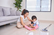 © makistock - mum teaching daughter cleaning their home living room at weekend. A young woman and a little child girl dusting. family housework and household concept.