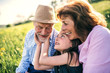 © Halfpoint - Senior couple with granddaughter outside in spring nature, relaxing on the grass.