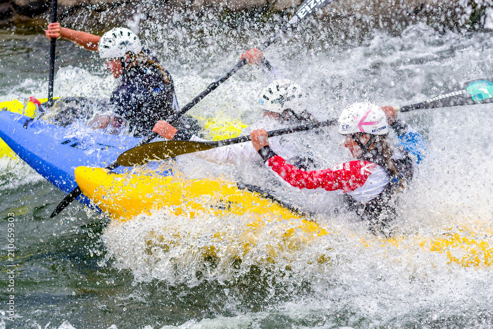 Athletes competing in extreme canoe slalom on whitewater river, dynamic ...