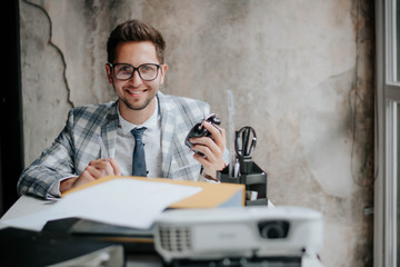 Business conference or lecture with businessman. projector in foreground/ job and succes.Photo young business manager working with new startup project in modern office.Analyze document, plans.