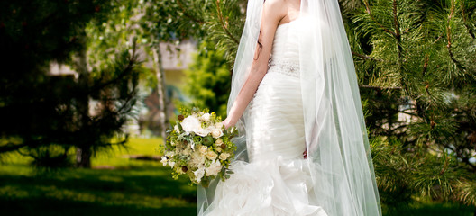 Canvas Print - Young bride in wedding dress holding bouquet