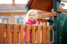 Cute Little Girl Having Fun On Outdoor Playground