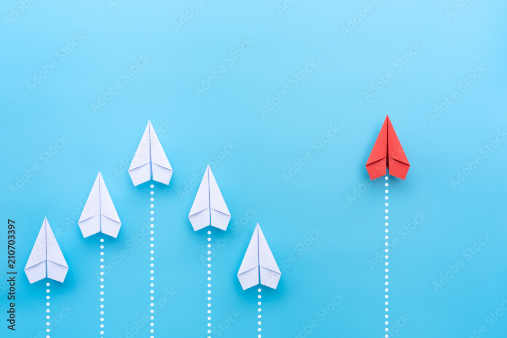 Group of paper plane in one direction and with one individual pointing in the different way on blue background. Business for innovative solution concept. - obrazy, fototapety, plakaty 