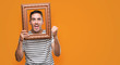 © Krakenimages.com - Handsome young man looking through vintage art frame screaming proud and celebrating victory and success very excited, cheering emotion