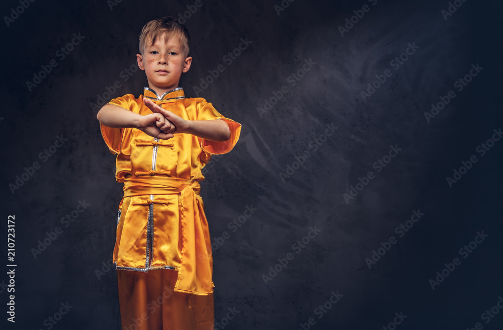 Cute boy dressed in the traditional costume of a Tibetan monk shows the tricks from the wellness complex at the studio.