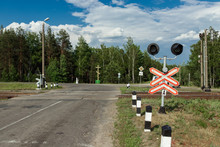 Rural Level Crossing With The Barriers Down And Flashing Red Light To Warn Motorists Of An Oncoming Train