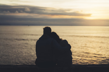 Couple hugging on background beach ocean sunrise, meeting of lovers concept, silhouette two romantic people cuddling on evening seascape, hipster enjoy sunset together, travel holidays vacation relax