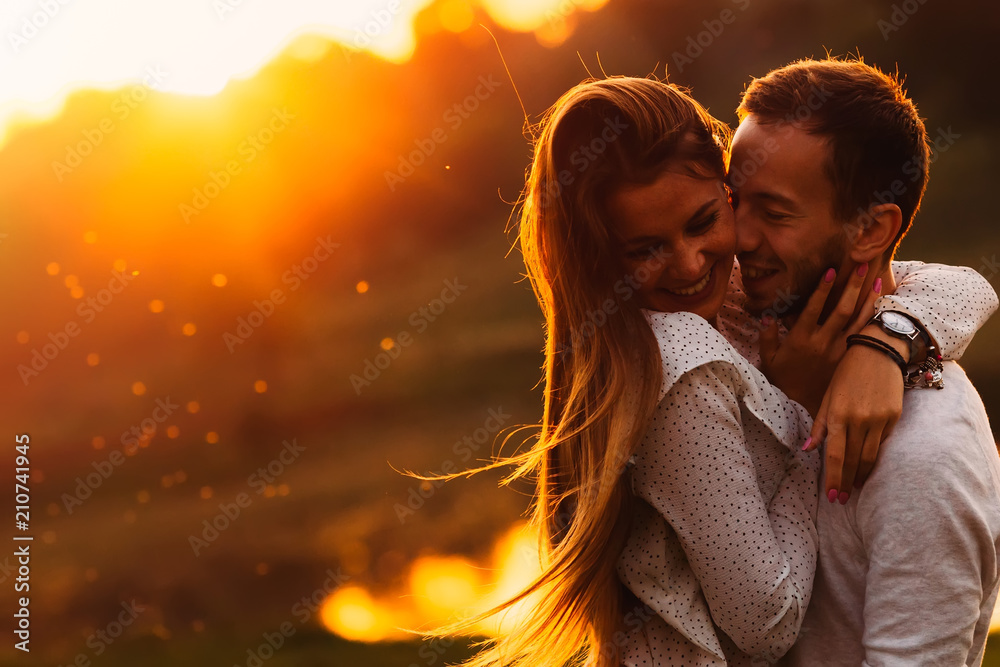 sensual hugs of a guy and his girlfriend against the background - obrazy, fototapety, plakaty 