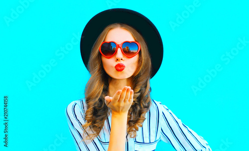 Cool girl with red lips is sends an air kiss in a sunglasses shape of heart over Tableau sur Toile