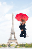Fototapeta Paryż - Happy woman travel in paris, france. Woman jump with fashion umbrella. Girl with beauty look at eiffel tower. Parisian isolated on white background. Travelling and wanderlust. Enjoy summer vacation