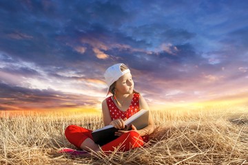 Child reading book or bible outdoors . Young Child's Hands Praying on Holy Bible .  Inner world of the child  . Relaxation in the fresh air . Portrait 