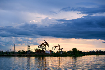 Wall Mural - The oil pumping units  and cloudscape sunset.