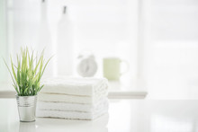 Towels On White Table With Copy Space On Blurred Bathroom Background