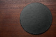 Round stone plate on wooden background