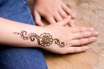 henna tattoo on small girl hand. Mehndi is traditional Indian decorative art. Close-up, overhead view - beauty concept