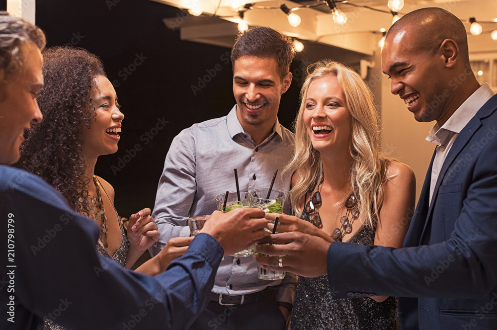 Friends toasting cocktail at night party - obrazy, fototapety, plakaty 