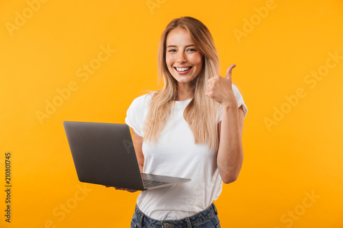 Fotomural Portrait of a smiling young blonde girl holding laptop