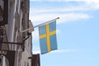 Swedish flag flying from building against blue sky