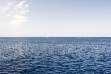 A view of a horizon at the seascape with two sailing yachts in aegean sea