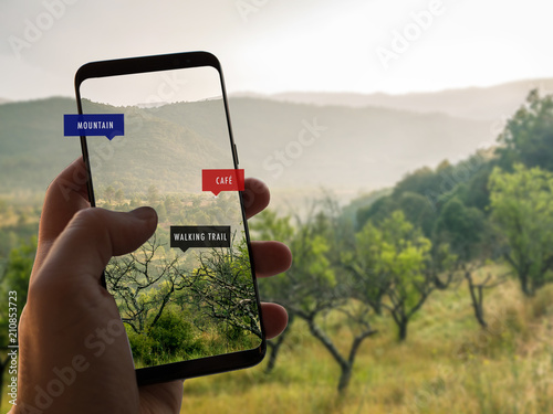 Augmented reality. Hand is holding a smart phone with AR app. Mobile  information about walking or trekking trails in the forest. - Buy this  stock photo and explore similar images at Adobe
