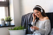 © lordn - Portrait of beautiful smiling young woman with headphones indoors listening music
