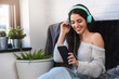 © lordn - Portrait of beautiful smiling young woman with headphones indoors listening music
