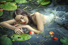 Beautiful Mermaid Girl In A White Dress In A Swamp With Water Lilies