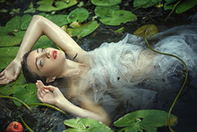 Beautiful Mermaid Girl In A White Dress In A Swamp With Water Lilies