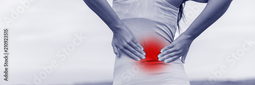 Cuadros en Lienzo Back pain - woman having painful muscle injury in lower back