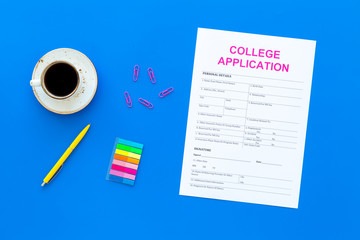Higher education. College application form ready to fill near coffee cup and stationery on blue background top view