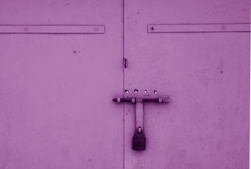 Wall Mural - Old padlock on metal gate in purple color.