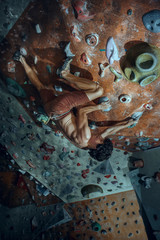 Wall Mural - Free climber young man climbing artificial boulder indoors