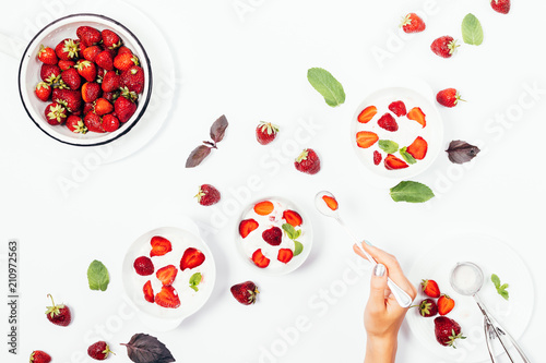 Fotografía Female's hand holding spoon over a bowl of strawberry ice cream