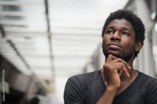 Thoughtful African man thinking; portrait of pensive young adult african man thinking about plan, idea, future, brain storming concept; west African young adult man model