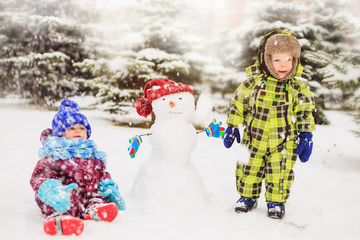 Funny kids are playing in the winter park.