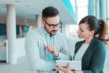 Confident business partners discussing work in office building