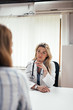 © bnenin - Seious female doctor listening to a patient in the office.