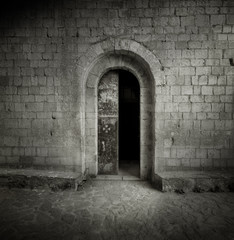  Black and white photographic film shot of medieval gate. Castle entrance door.