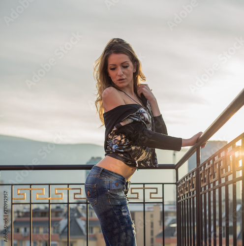 Beautiful Woman With Blonde Hair In Black Blouse And Jeans Posing