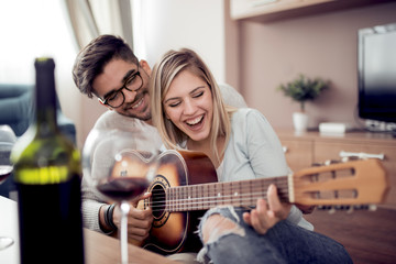 Wall Mural - Young couple enjoying wine at home