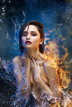 Beautiful Topless Brunette Girl Surrounded With Sparkling  Water Splashes And Fire Flames On Her Naked Shoulder Covers Her Breast With Her Hands An In Theatrical Smoke. Concept Art