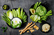 © sveta_zarzamora - Green vegetables snack board with various dips. Yogurt sauce or labneh, hummus, herb hummus or pesto with crackers, grissini bread, fresh vegetables. Healthy raw summer platter.