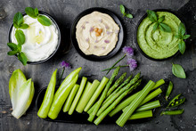 Green Vegetables Raw Snack Board With Various Dips. Yogurt Sauce Or Labneh, Hummus, Herb Hummus Or Pesto With Fresh Vegetables. Middle Eastern Meze Snacks Set