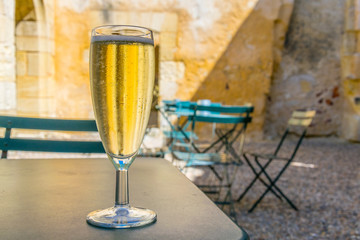 Wall Mural - Glass with wine situated inside of the Les Cordeliers cloister in Saint Emilion, France